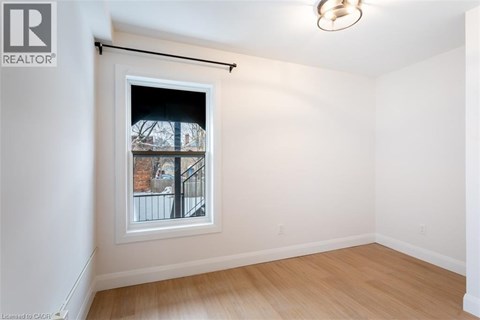 A room with a window showing a view of a building outside.