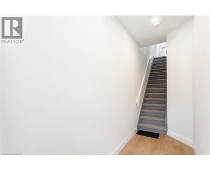 A staircase with a carpeted step leading up to a light on the ceiling.