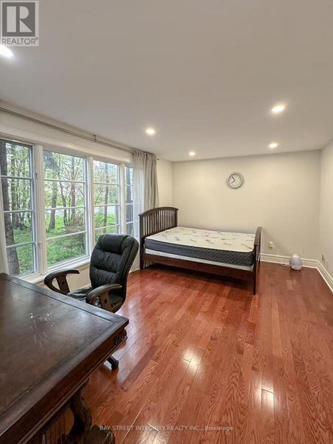 A bedroom with a bed, desk, and chair.