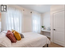 A bedroom with a white bed and a white door.