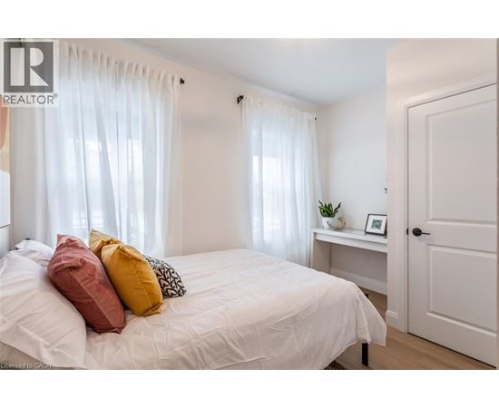 A bedroom with a white bed and a white door.
