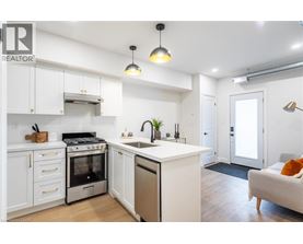 A modern kitchen with white cabinets and stainless steel appliances.