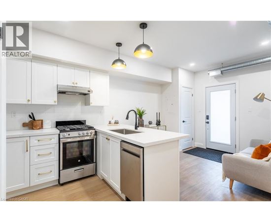 A modern kitchen with white cabinets and stainless steel appliances.
