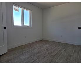 A room with a window and wooden flooring.