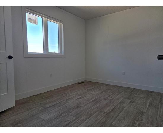 A room with a window and wooden flooring.