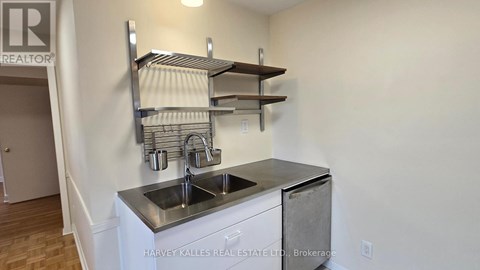 A stainless steel kitchen sink with a shelf above it.