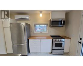 A kitchen with a refrigerator, oven, microwave, and cabinets.