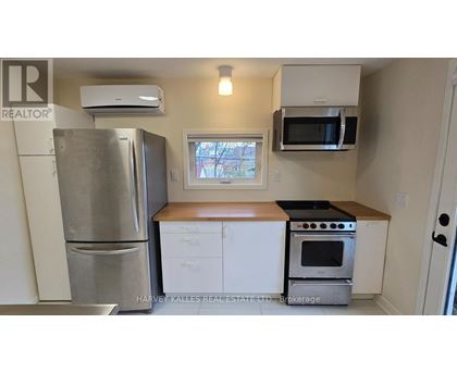 A kitchen with a refrigerator, oven, microwave, and cabinets.