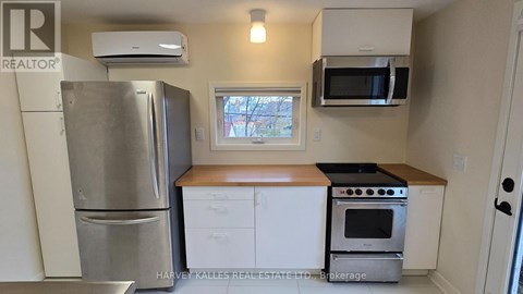 A kitchen with a refrigerator, oven, microwave, and cabinets.
