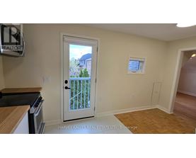 A real estate sign is on the wall in a room with a door leading to a balcony.