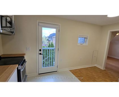 A real estate sign is on the wall in a room with a door leading to a balcony.