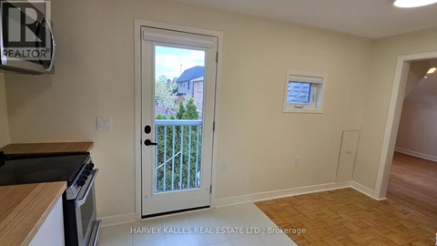 A real estate sign is on the wall in a room with a door leading to a balcony.