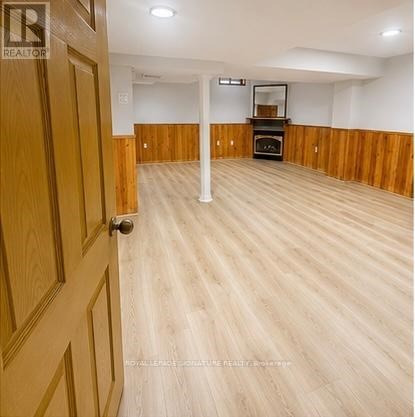 A room with wooden floors and a door on the left.