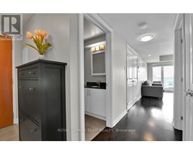 A modern kitchen with a black cabinet and a vase of flowers on top.
