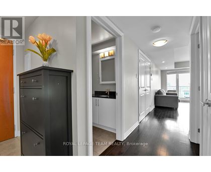 A modern kitchen with a black cabinet and a vase of flowers on top.