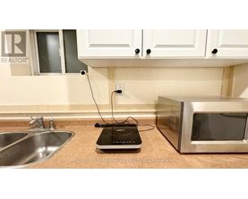 A kitchen counter with a microwave and a sink.