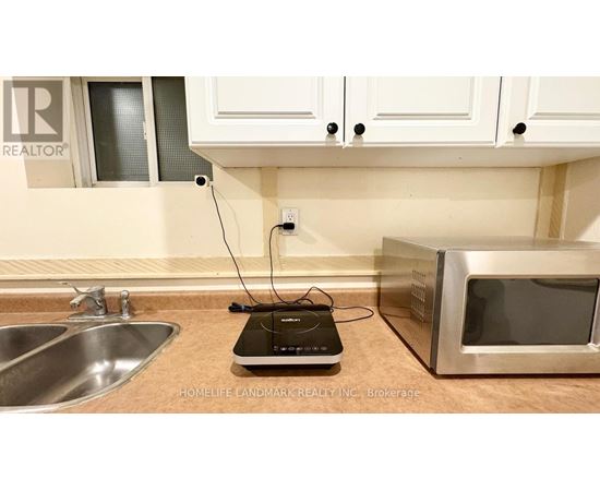 A kitchen counter with a microwave and a sink.