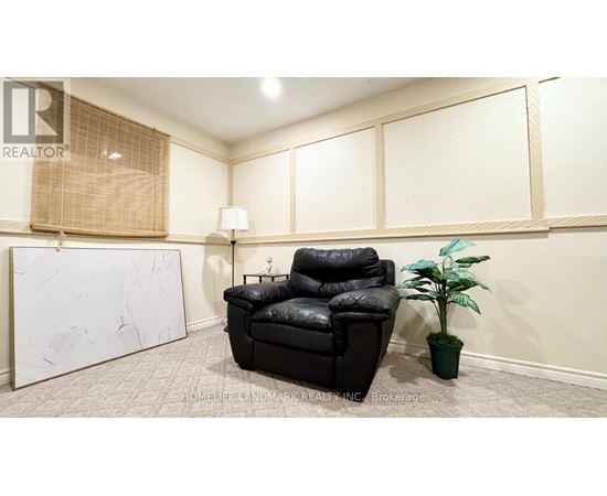 A black leather chair sits in a room with a white wall and a plant.