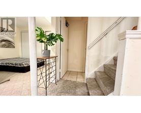 A room with a staircase and a bed.
