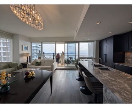 A modern kitchen with a large island and a dining table with chairs.