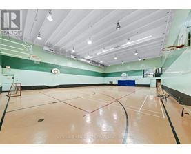 A gym with a basketball hoop and a basketball court.