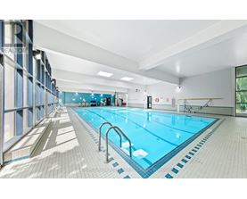 A large indoor swimming pool with blue water and white tiles.