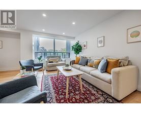 A living room with a couch, chairs, and a rug.