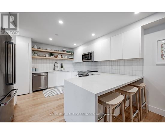 A modern kitchen with white cabinets and a white island.