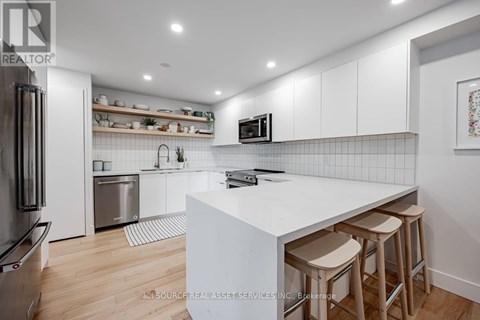 A modern kitchen with white cabinets and a white island.