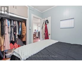 A bedroom with a large bed and a closet full of clothes.