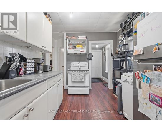 A kitchen with white cabinets and a white dishwasher.