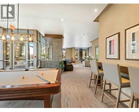 A pool table is in the middle of a room with chairs around it.