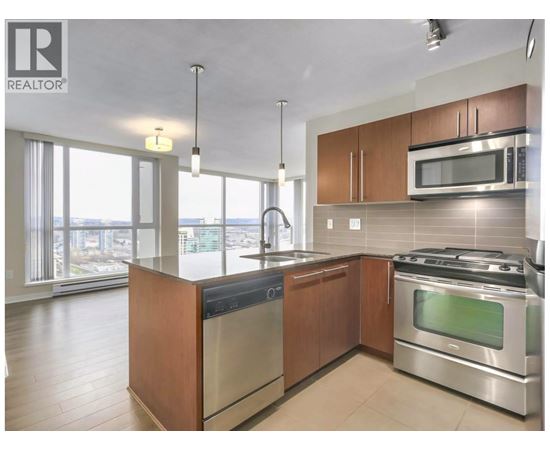 A modern kitchen with stainless steel appliances and wooden cabinets.