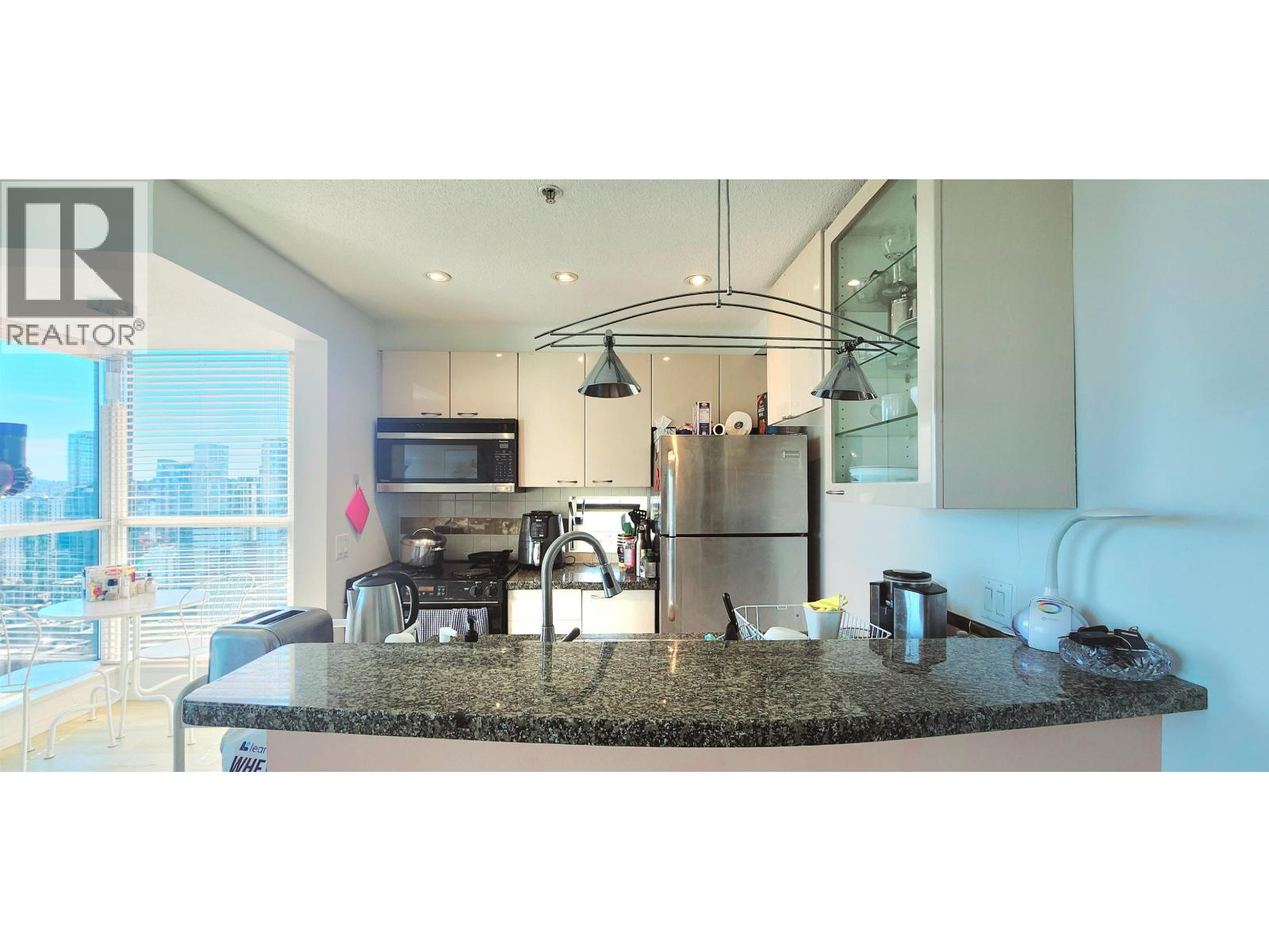 A modern kitchen with granite countertops and stainless steel appliances.