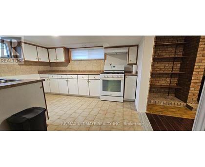 A kitchen with white cabinets and a brick wall.