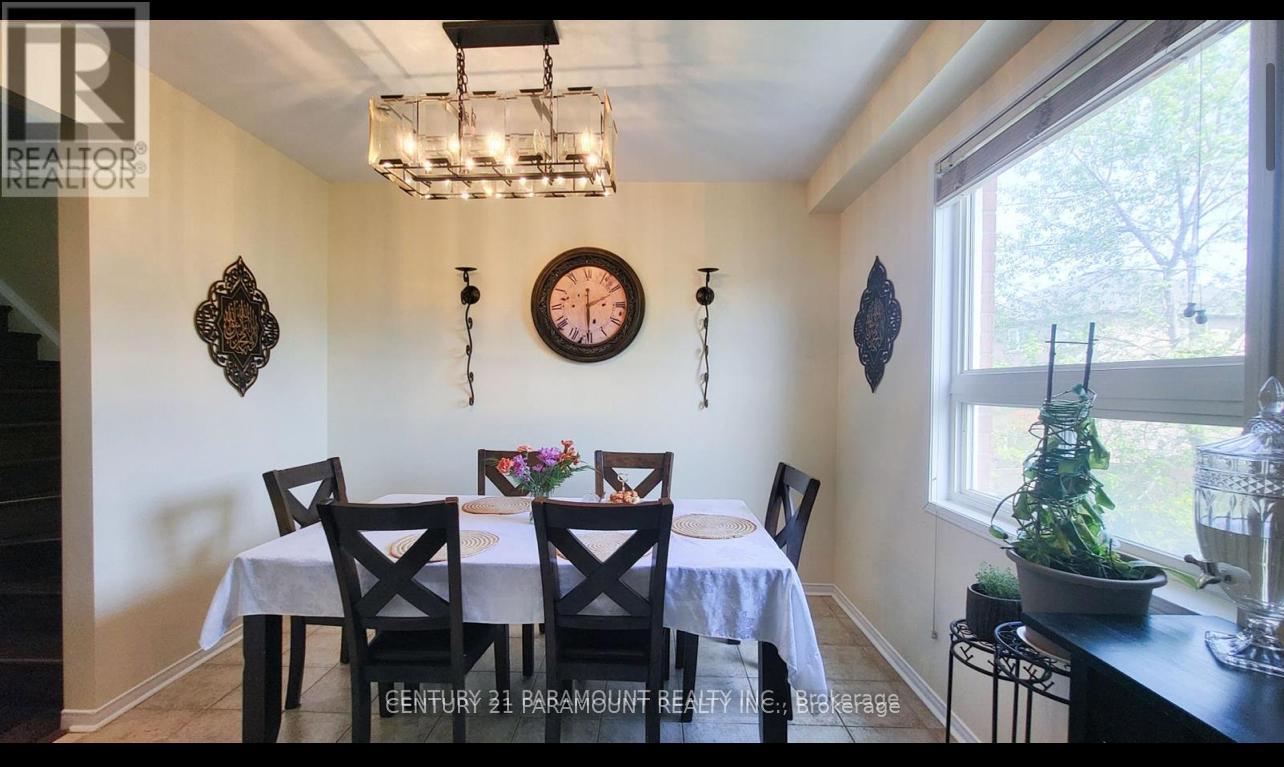 A dining room with a table set for four and a chandelier hanging from the ceiling.