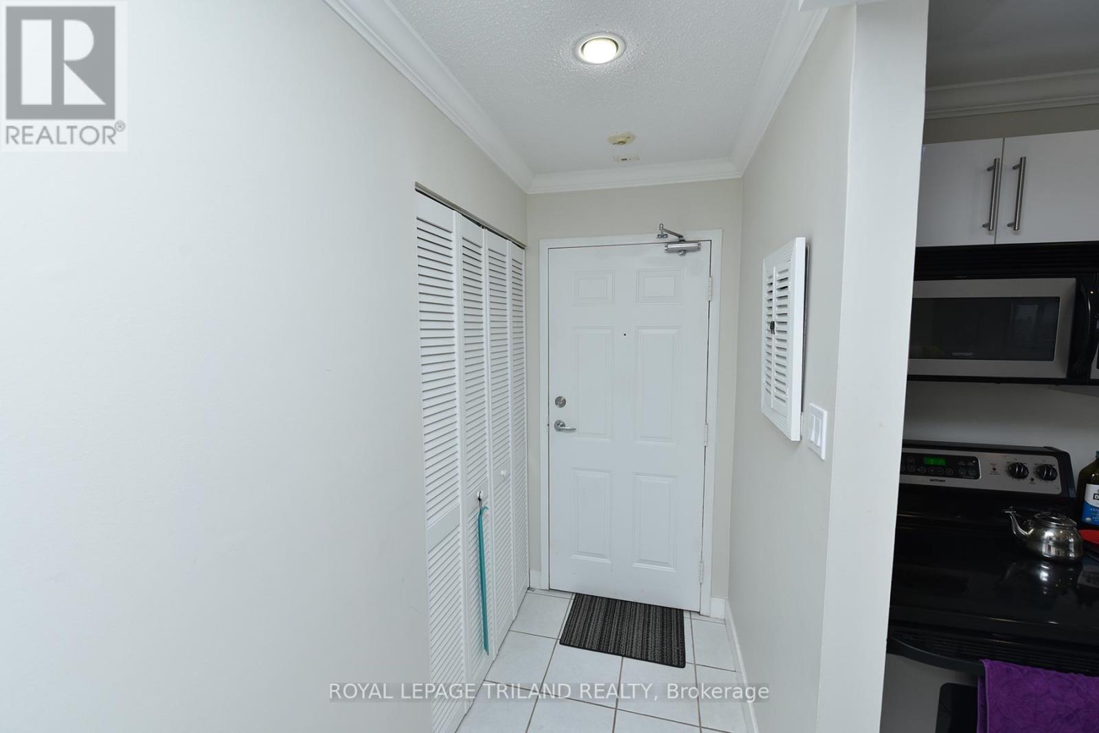 A white door is in a hallway with a black counter top.