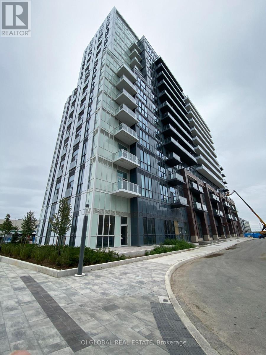 A modern multi-story building with a glass facade and balconies.