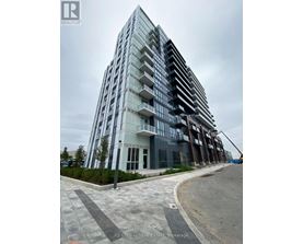 A modern multi-story building with a glass facade and balconies.
