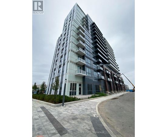 A modern multi-story building with a glass facade and balconies.