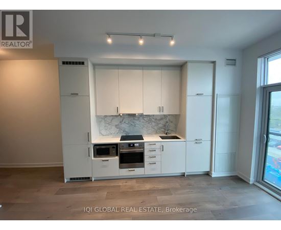 A modern kitchen with white cabinets and appliances.
