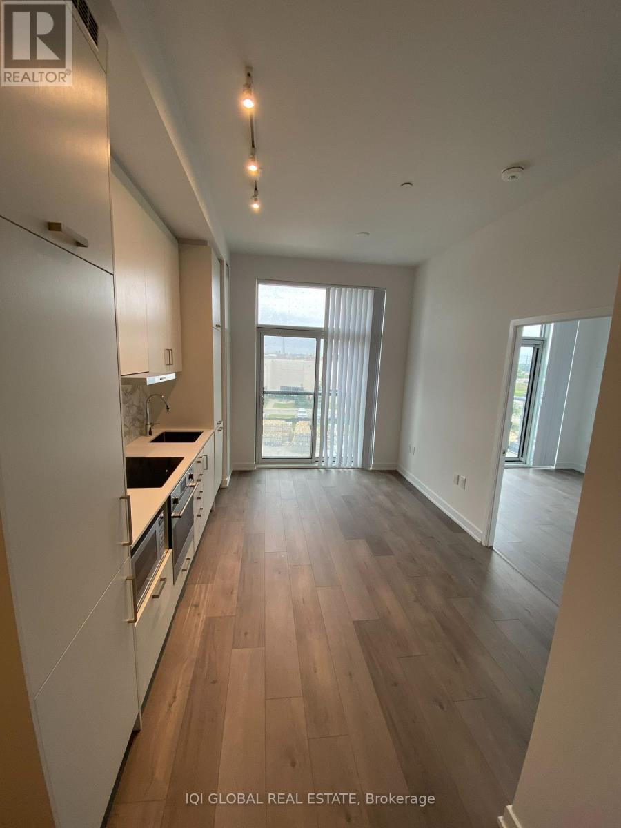A modern kitchen with wooden floors and white cabinets.