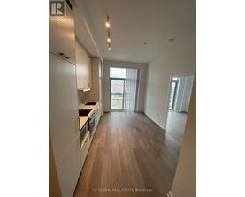 A modern kitchen with wooden floors and white cabinets.