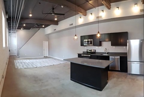 A kitchen with black countertops and stainless steel appliances.