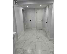 A hallway with marble floors and white walls.