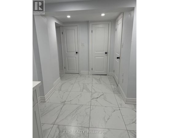 A hallway with marble floors and white walls.