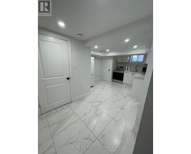 A white marble tiled kitchen and living room with a sliding door.