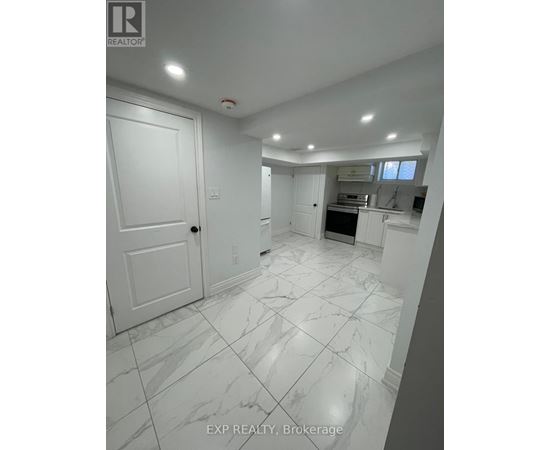A white marble tiled kitchen and living room with a sliding door.