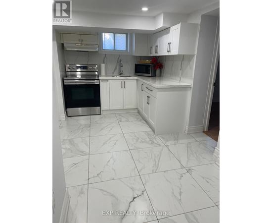 A white kitchen with a marble floor.