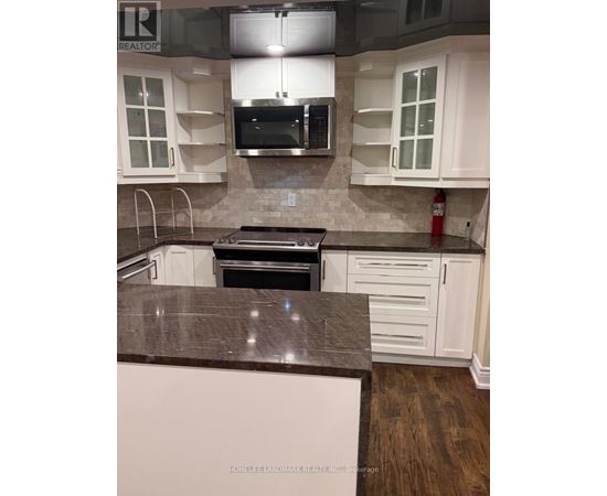 A kitchen with white cabinets and a brown countertop.